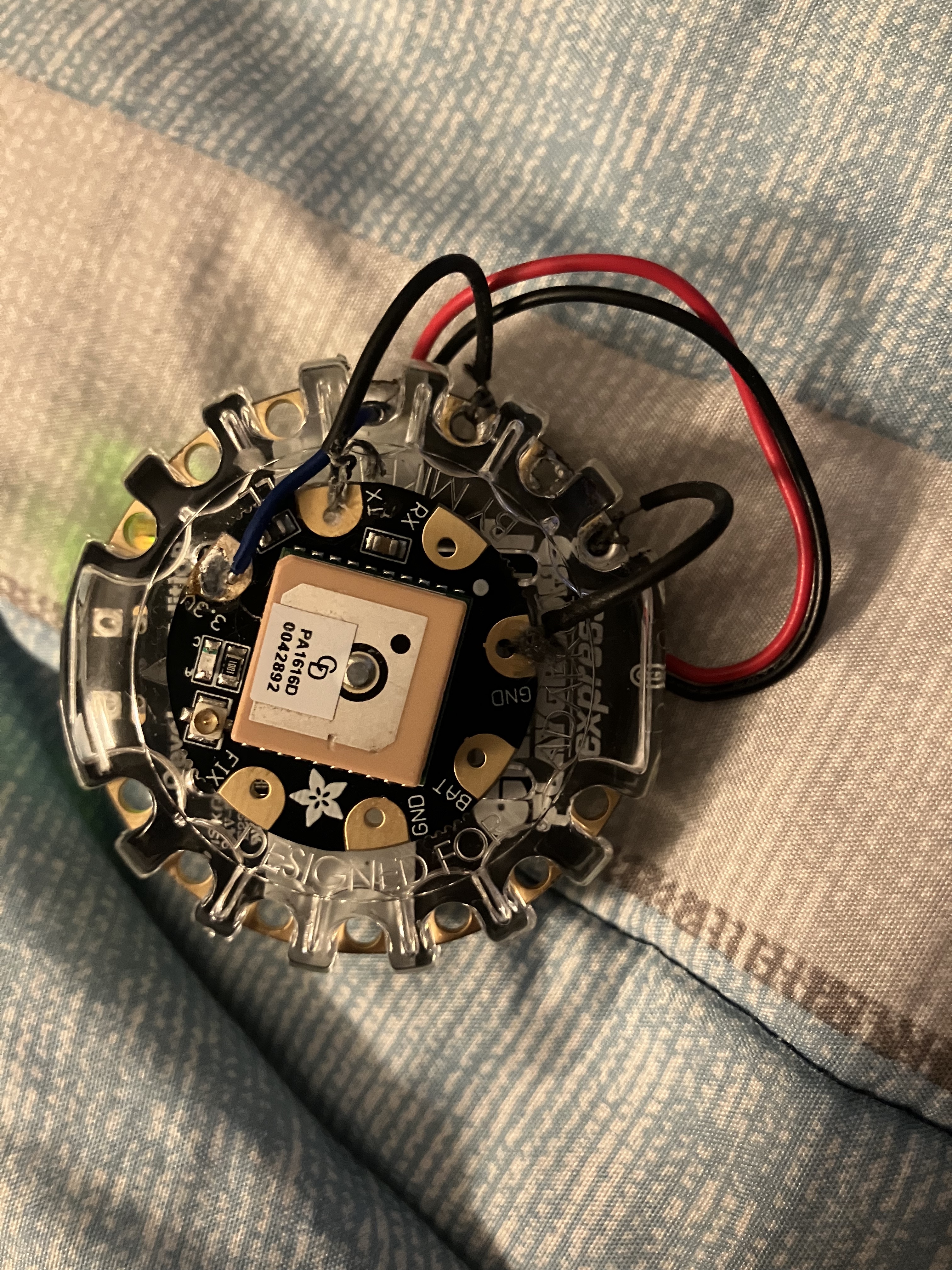 Front of the circular prototype board with an attached GPS module and square patch antenna