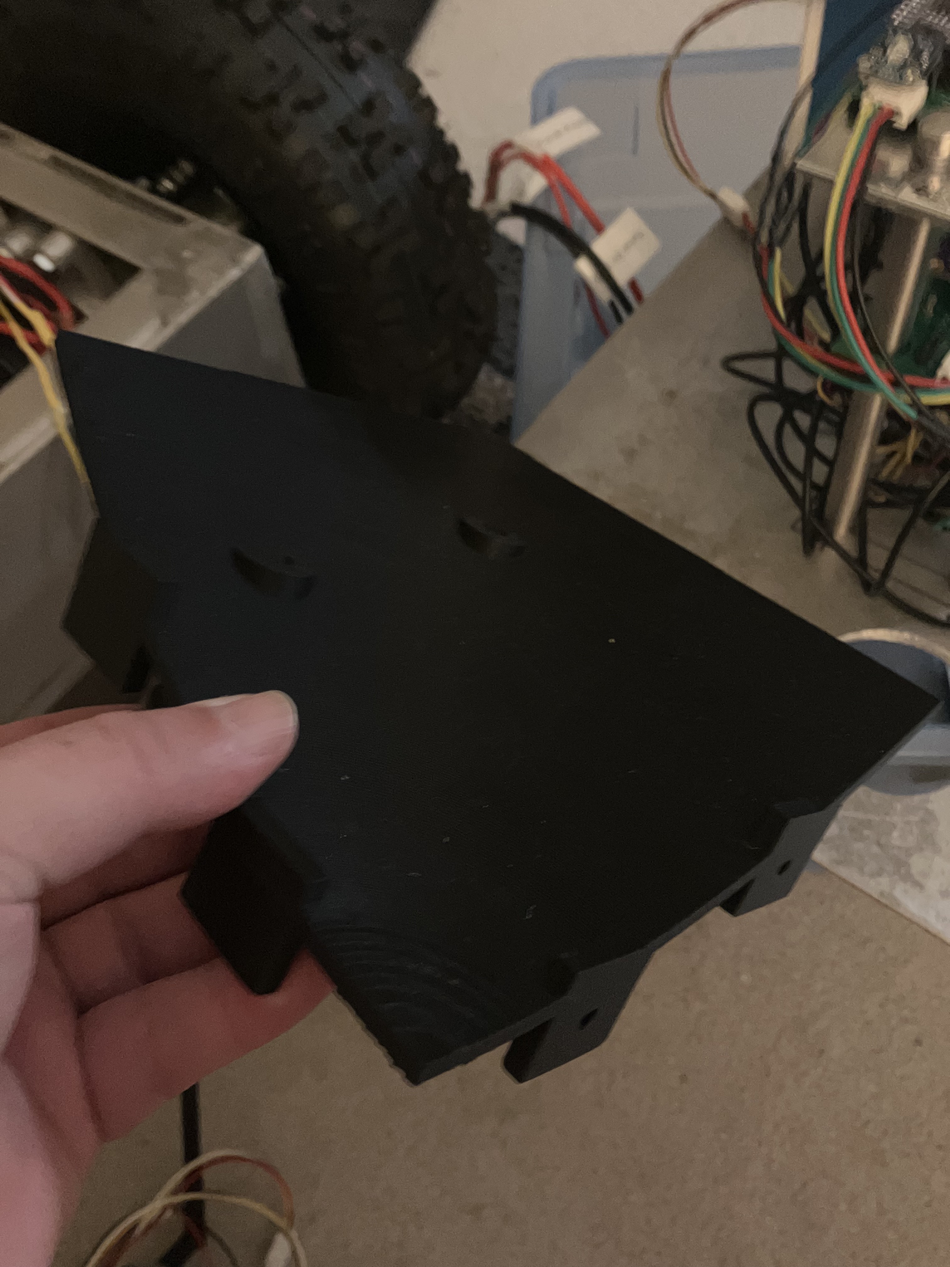 Black quarter-segment catch-bowl prototype held beside the Recon Rover chassis